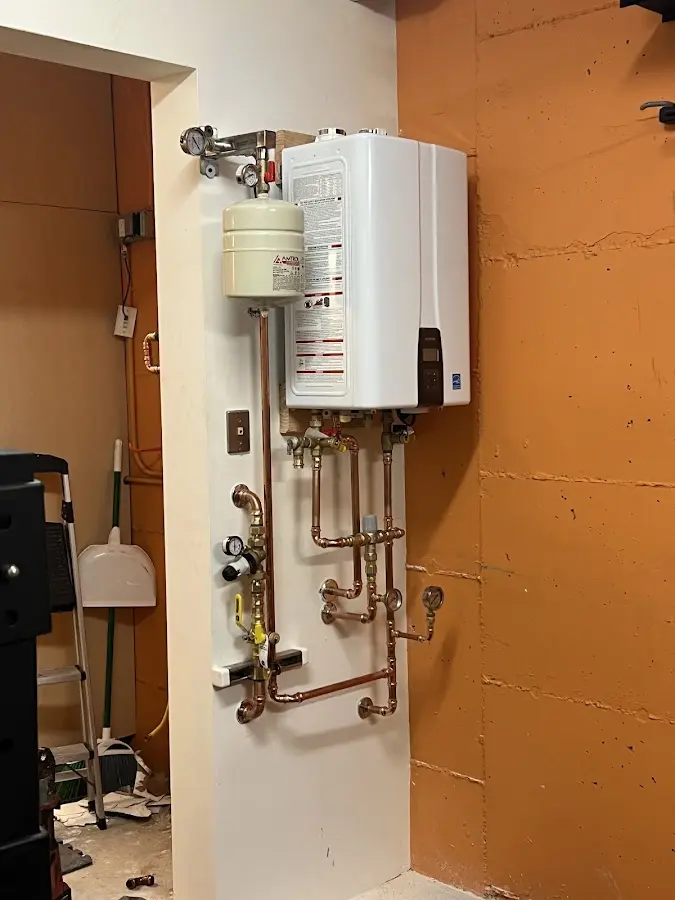 Plumbing technician inspecting water heater connections in Leland